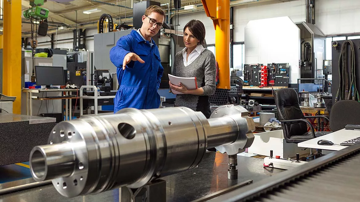 Managing director talking to an employee on the factory floor.