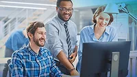 Three office workers, smiling and looking at a computer. Three office workers, smiling and looking at a computer.