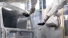 Painting car using robotic machine in production.