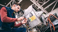 Aircraft mechanic working on the jet engine in a hangar Aircraft engineer in the hangar repairing and maintaining airplane jet engine.