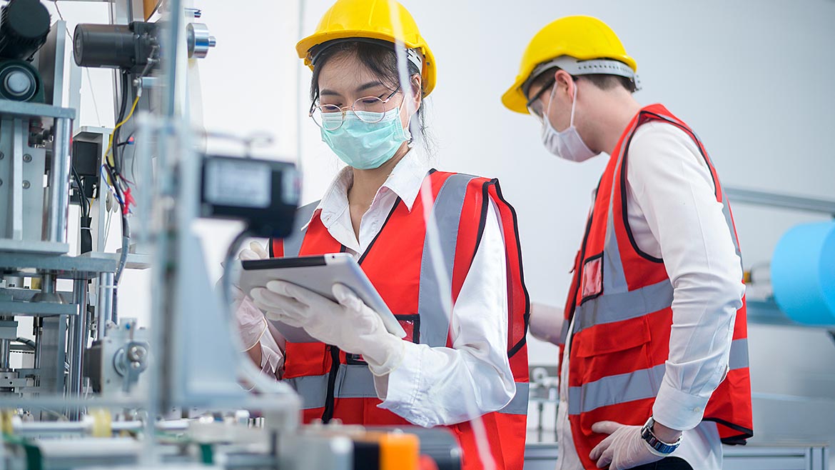 Quality control (QC) engineer monitoring and checking machine systems in a manufacturing factory.
