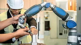 Asian male engineer working with a hand robot ai machine.