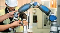 Asian male engineer working with a hand robot ai machine.