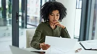 Young businesswoman going over paperwork in a modern office Shot of a young businesswoman going over paperwork in a modern office.