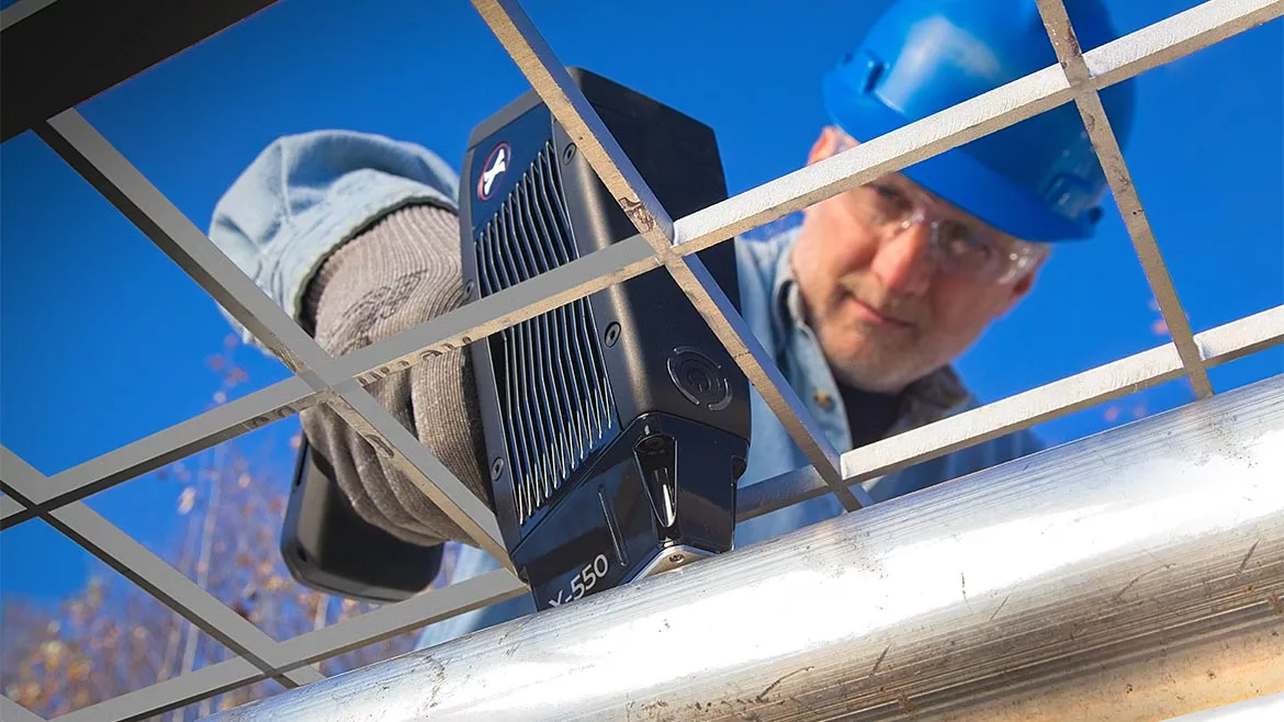 Worker using the SciAps X-550 handheld XRF analyzer.