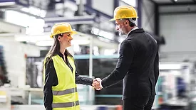 Female warehouse manager talking with logistics employee in warehouse, planning transport of products, goods, talking shipping process.