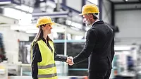 Female warehouse manager talking with logistics employee in warehouse, planning transport of products, goods, talking shipping process.