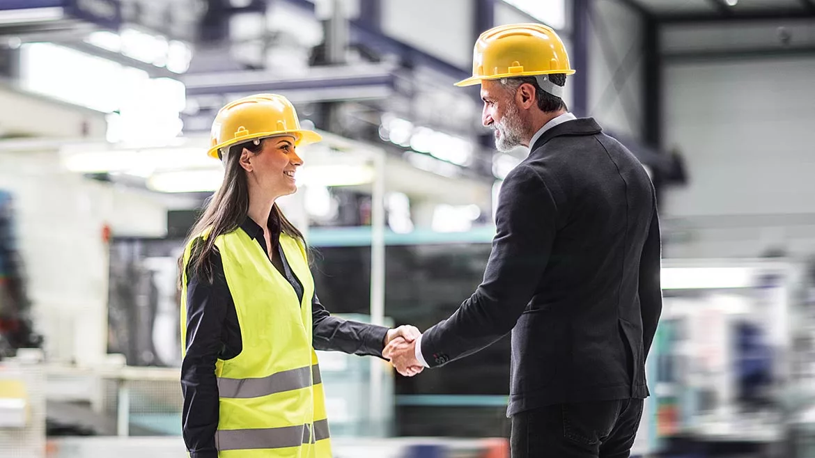 Female warehouse manager talking with logistics employee in warehouse, planning transport of products, goods, talking shipping process.