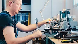Professional calibration of pressure gauges and sensors. Working person sits at desk and is engaged in verification of instrumentation.
