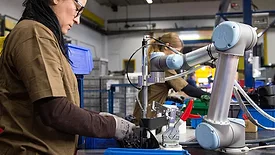 Lean IMEC: Two women working on universal robots, cobot