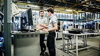 Two printing factory engineers working at a console together Two printing factory engineers working at a console together.