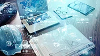 Industrial technology concept layed over a work desk with a laptop, hardhat, glasses, table, folder on top.
