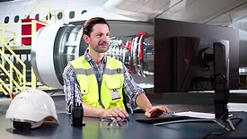 Man working on the computer in an airport hangar.