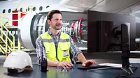 Man working on the computer in an airport hangar.