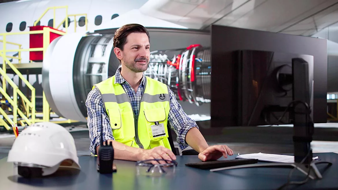 Man working on the computer in an airport hangar.
