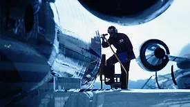Flight engineer in silhouette inspecting an airplane.