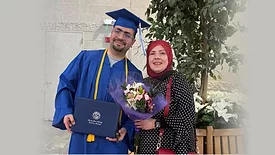 Ibrahim Intabli at his graduation posing with his mother.