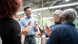 Coworkers celebrating some good news in a factory.