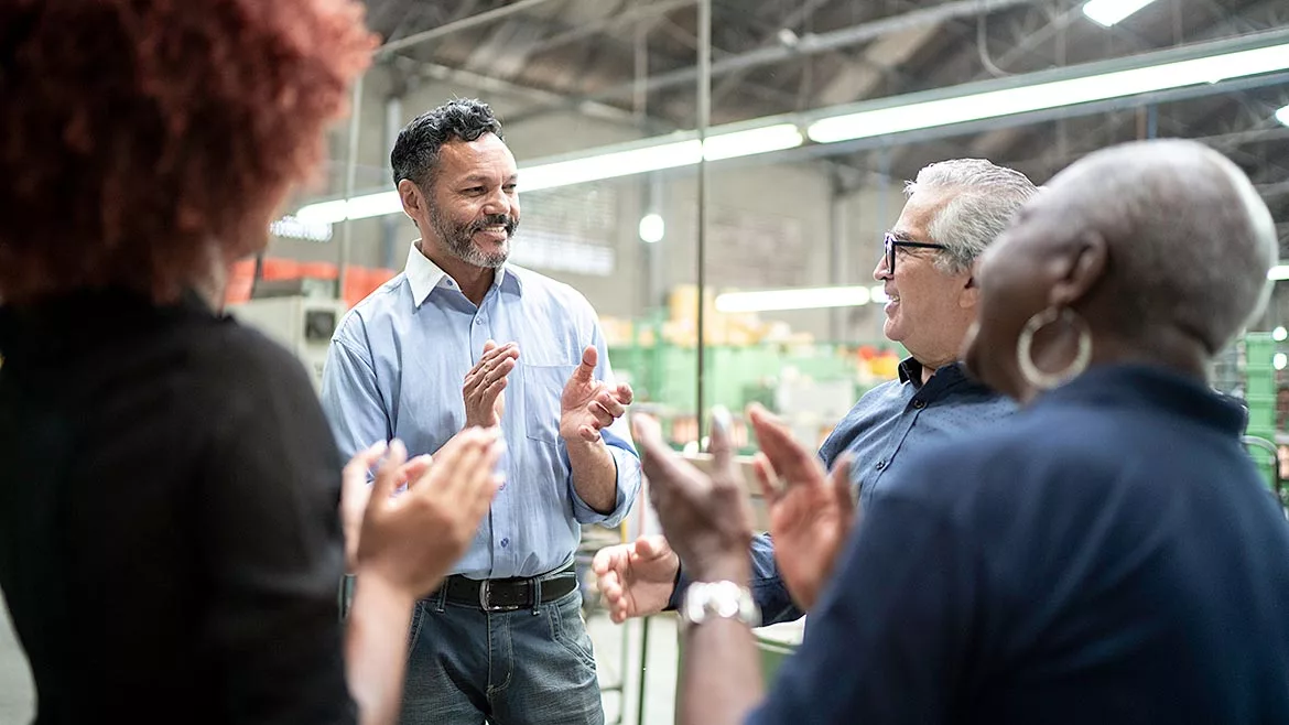 Coworkers celebrating some good news in a factory.