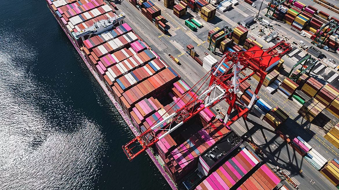 Aerial view of two ships docked at a container terminal.