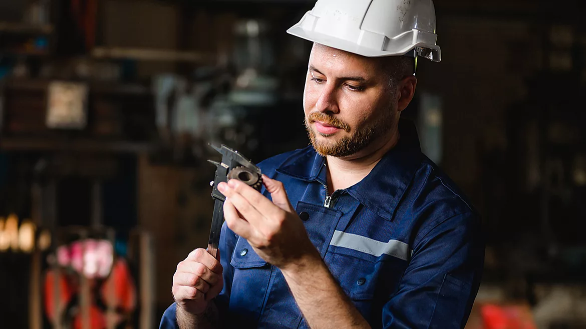 Professional male technician checking and repairing machinery.