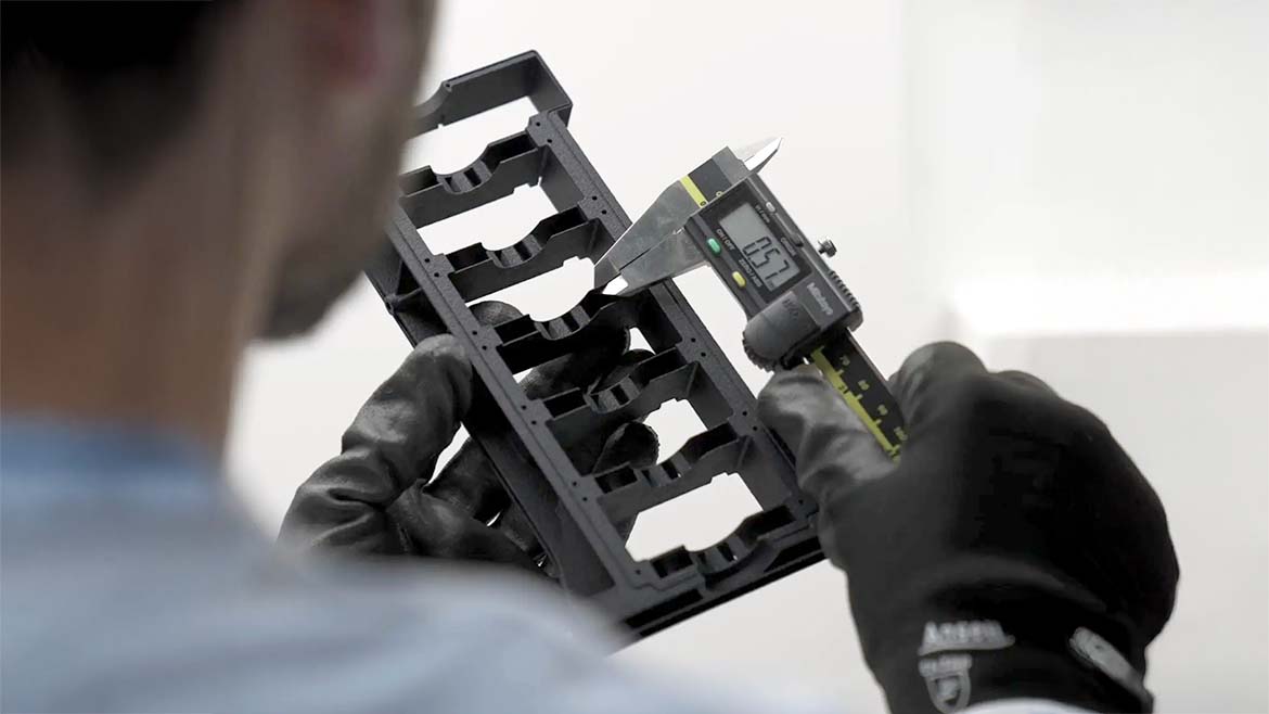 A person using a digital caliper. The person is blurred.