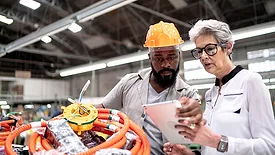 An engineer and a manager working together in a factory.