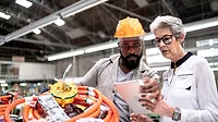 An engineer and a manager working together in a factory An engineer and a manager working together in a factory.