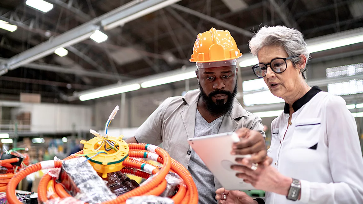 An engineer and a manager working together in a factory.