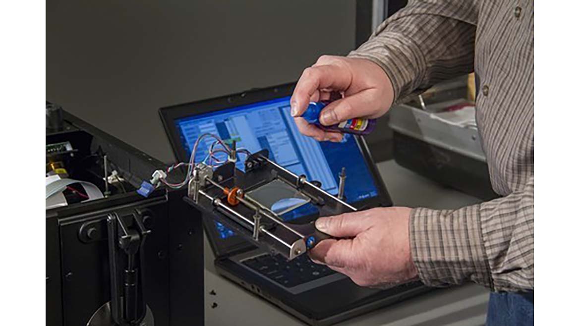 A technician performs annual servicing and certification on a spectrophotometer.