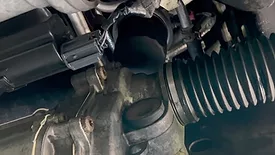 Close up image of engine with a dirty oil filter.