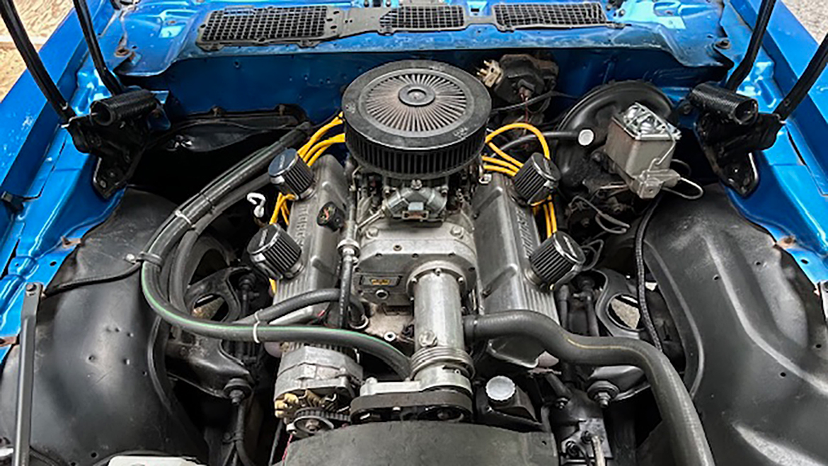 Blue car's engine under the open hood.