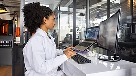 Health engineer working at a 3D printing laboratory using a computer to create a dental mold.