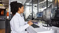 Health engineer working at a 3D printing laboratory using a computer to create a dental mold.