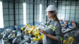 A female auditor inspects the company's robot assets in the warehouse before delivering them to customers.