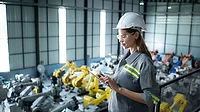 A female auditor inspects the company's robot assets in the warehouse before delivering them to customers.