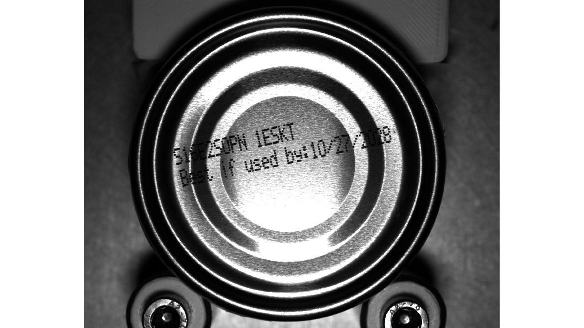 Top view of a food can label that's difficult to see due to light.