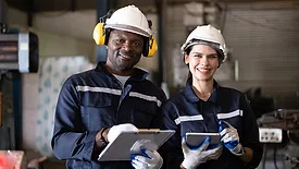 Two technicians engineers workers holding tablet checking and working together at factory.