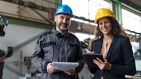 Female engineering manager and mechanic worker doing routine check up in industrial factory
