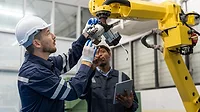 African engineers checking robotic arc welding with laptop at production line of factory African engineers checking robotic arc welding with laptop at production line of factory.