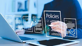 Businesswoman reviews virtual digital document policies with icons, checklists, certifications, and financial details with a blurred background. POV is behind a transparent screen.