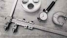 Metal measuring instruments on a wooden table.