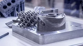 Man is holding object printed on metal 3d printer.