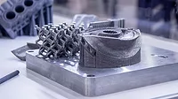 Man is holding object printed on metal 3d printer.
