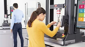 Operators perform materials analysis on universal testing equipment