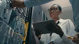 Shot of a man and woman using a digital tablet while working in a data centre.