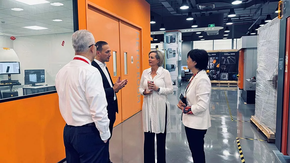 Four people standing in a hallway. Gemba Walk in China.