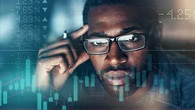 Digitally enhanced shot of a businessman working in the office, superimposed over a graph showing the ups and downs of the stock market.