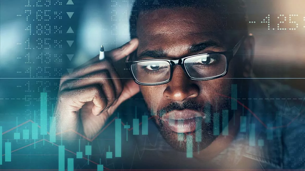 Digitally enhanced shot of a businessman working in the office, superimposed over a graph showing the ups and downs of the stock market.