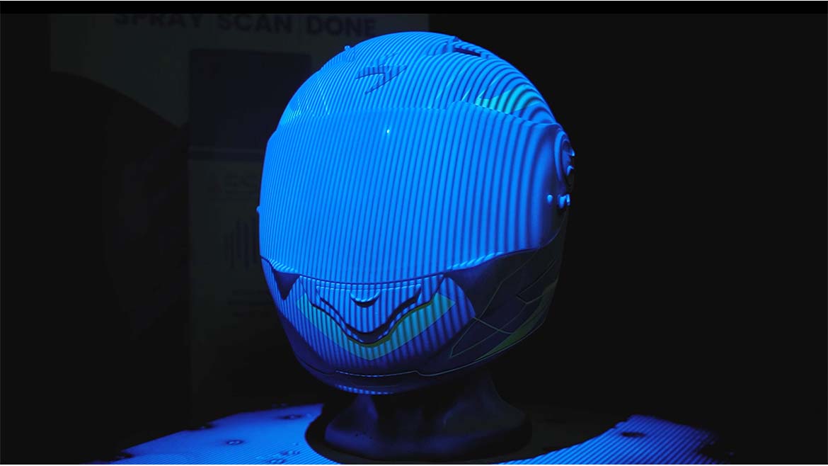 Matted helmet during the scanning process, dimly lit with a black background.